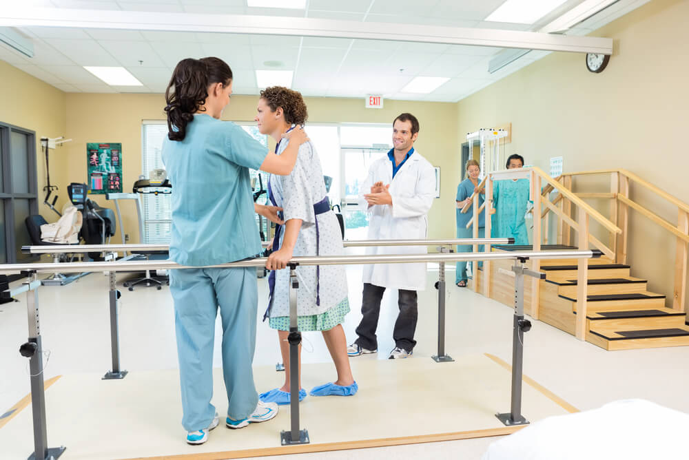 occupational therapists helping a patient walk