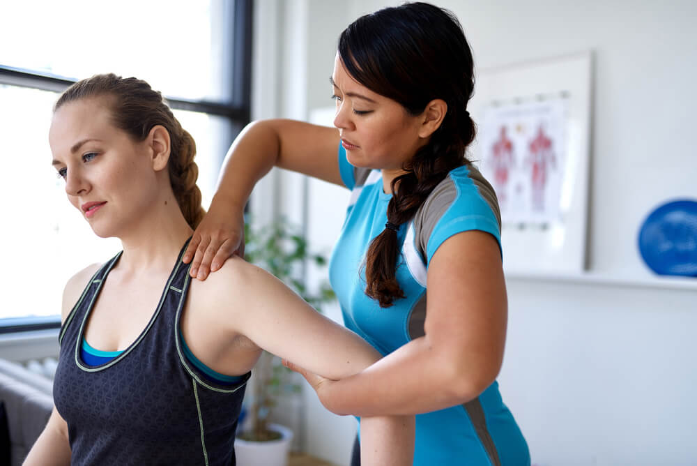 physiotherapist working with female client