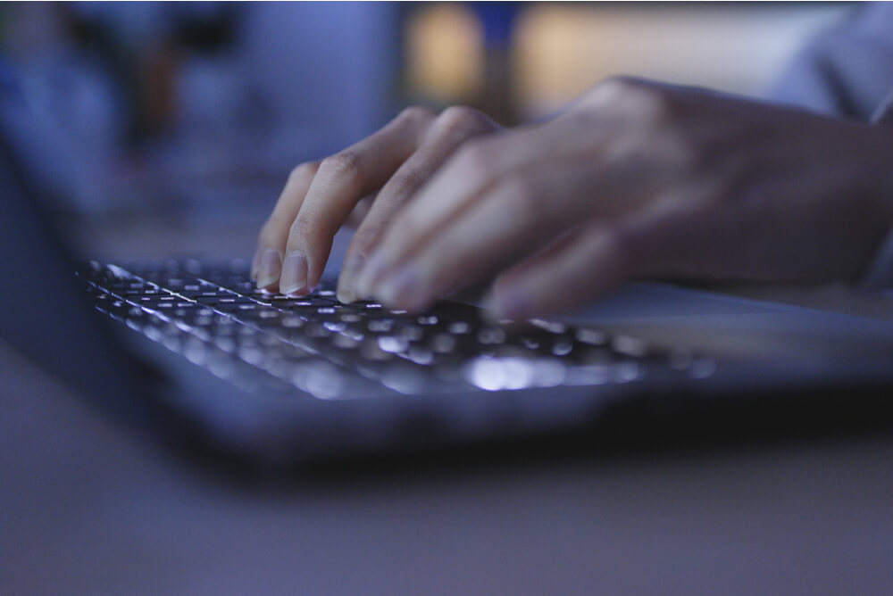 Person typing on a laptop, covered by cyber liability insurance