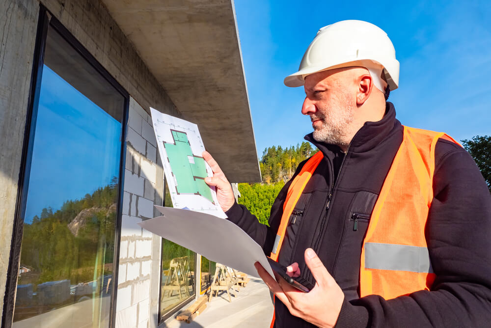 a man inspecting a wall under construction