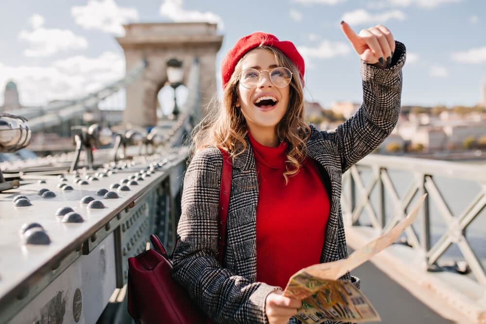 a woman with a map on a bridge in Paris pointing