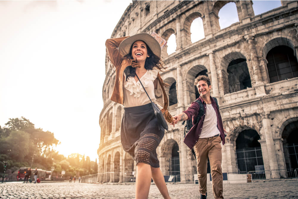 young couple with travel insurance at Rome Colosseum in Europe