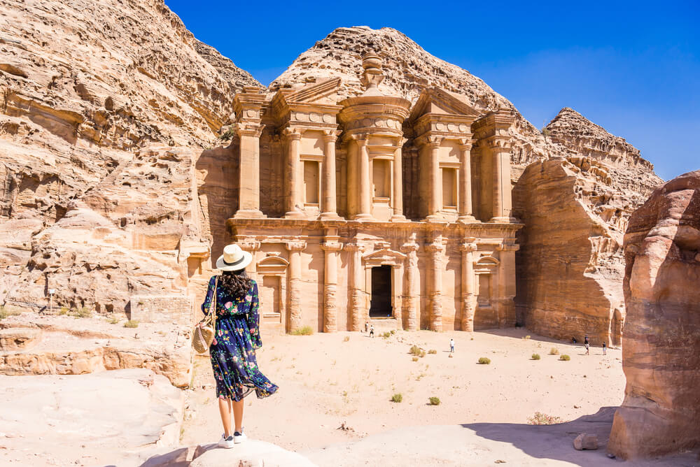 a female tourist standing outside the entrance to Petra in Jordan