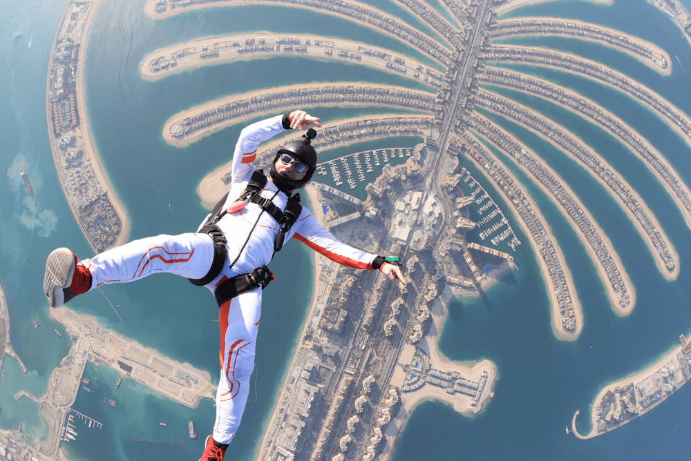 a man skydiving over man made Dubai Palm Islands