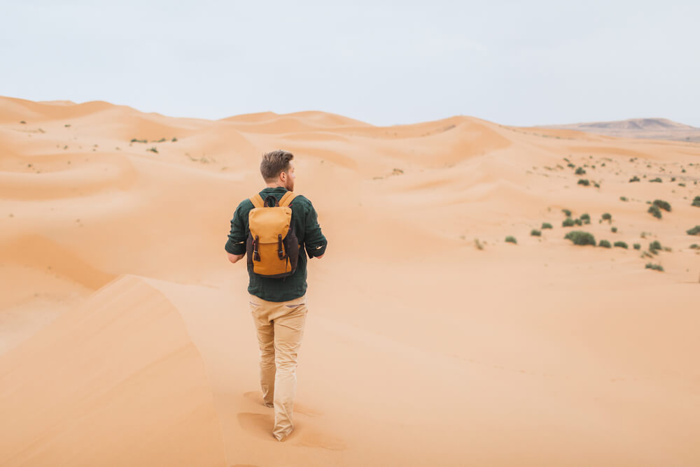 Man walking through Sahara deserts, Africa