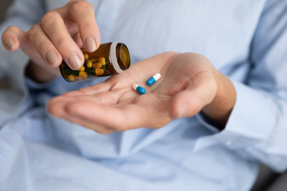 an older woman taking pills from a bottle