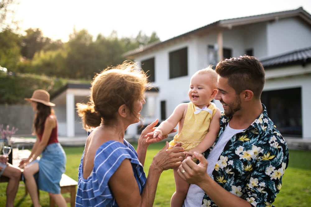 a family with a baby spending time with grandparents in backyard