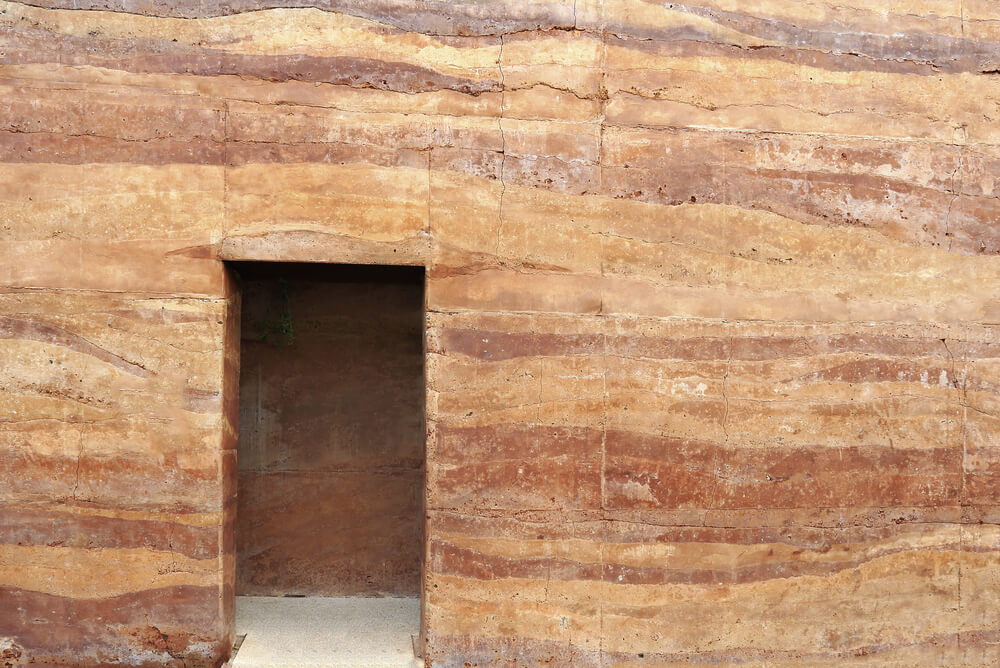a rammed earth wall with a doorway