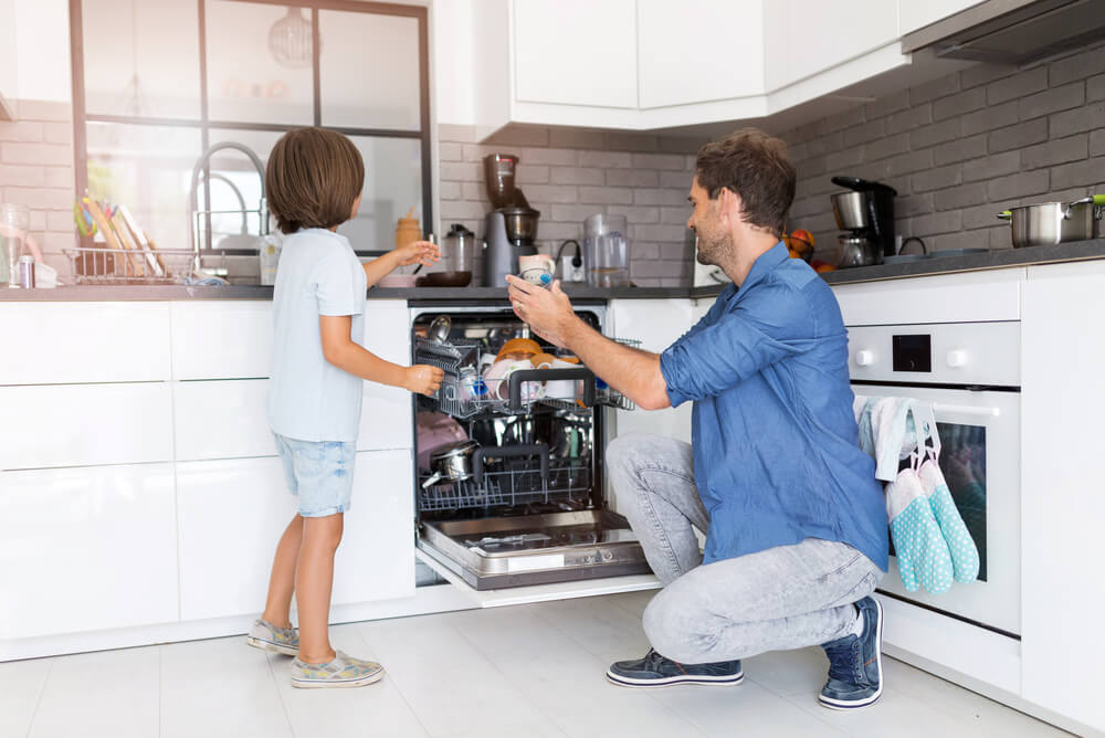 father and son loading dishwasher