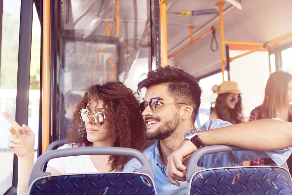 Couple sightseeing on a bus with travel insurance