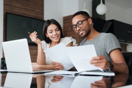 a couple with a computer and paper looking at the different types of mortgage offset accounts