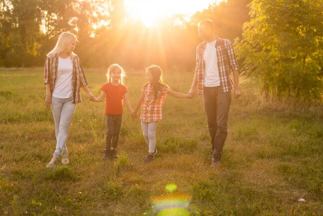 family walking on grass with life insurance