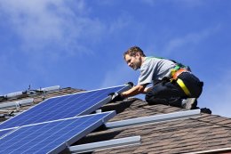 man installing solar pv system on roof