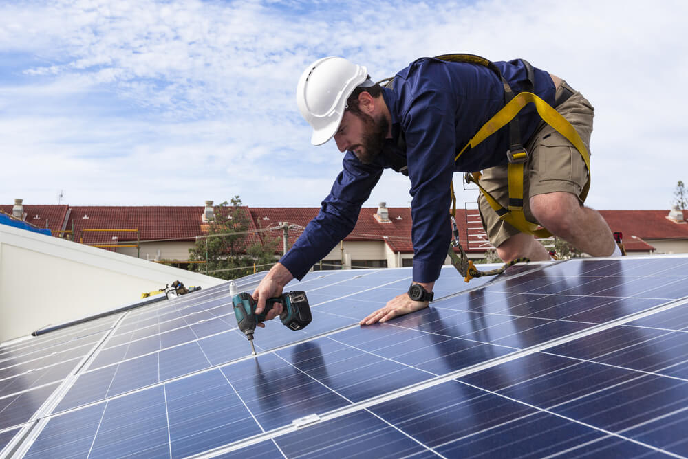 Man installing solar pv system on rooftop