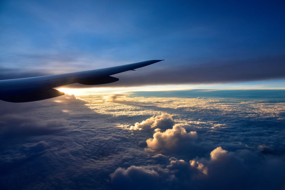 Wing of a plane in a low lit sky
