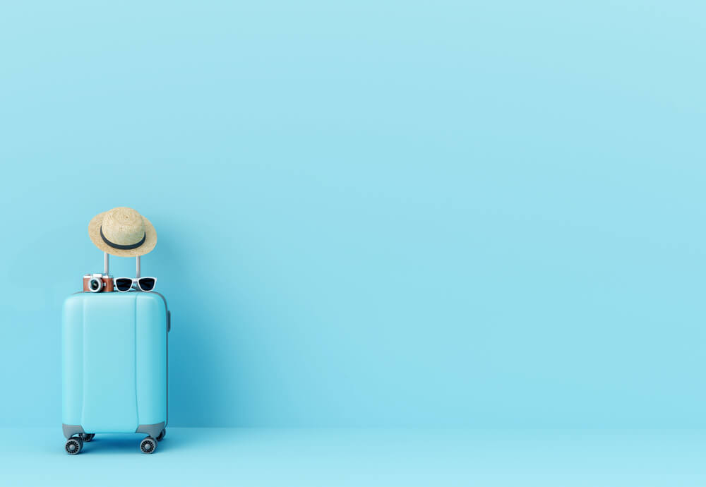 A blue suitcase in front of a blue wall
