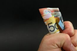 Hand holding rolled-up cash