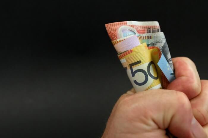 Hand holding rolled-up cash
