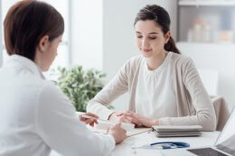 a woman who has health insurance with pre-existing conditions talking to doctor