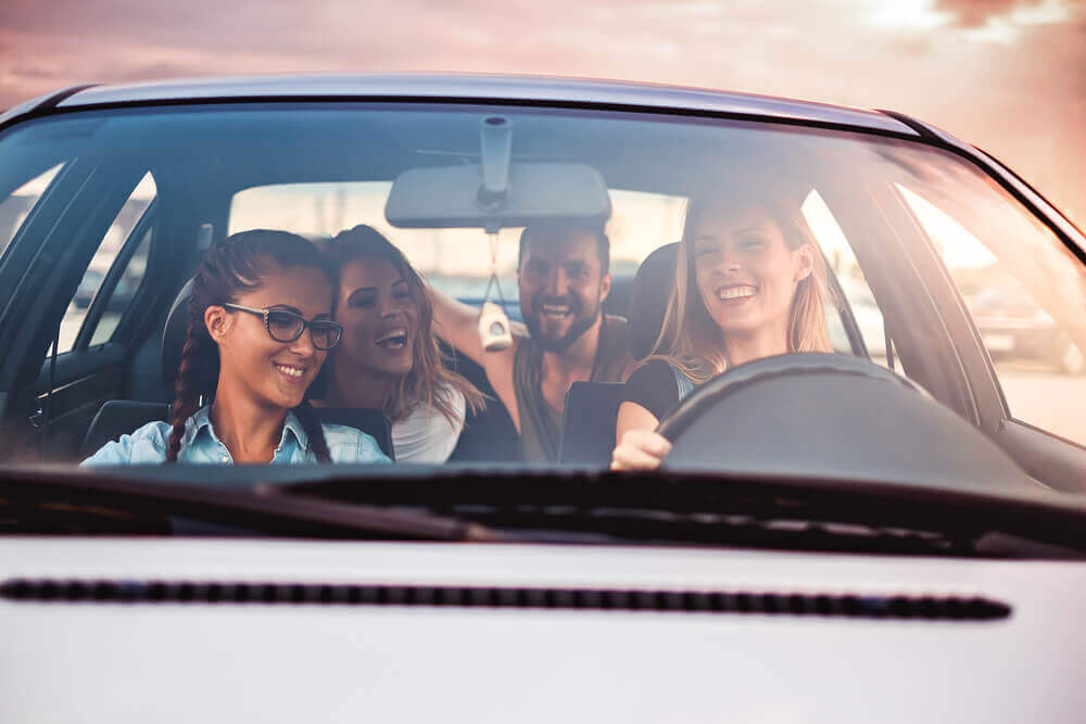 Group of friends driving while protecting by car insurance for young drivers
