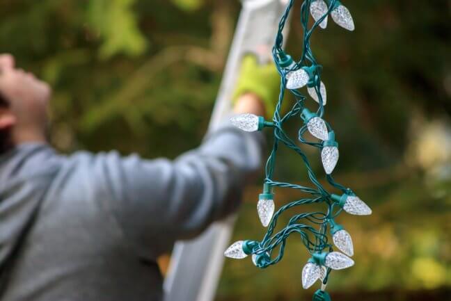 Man putting Christmas lights up