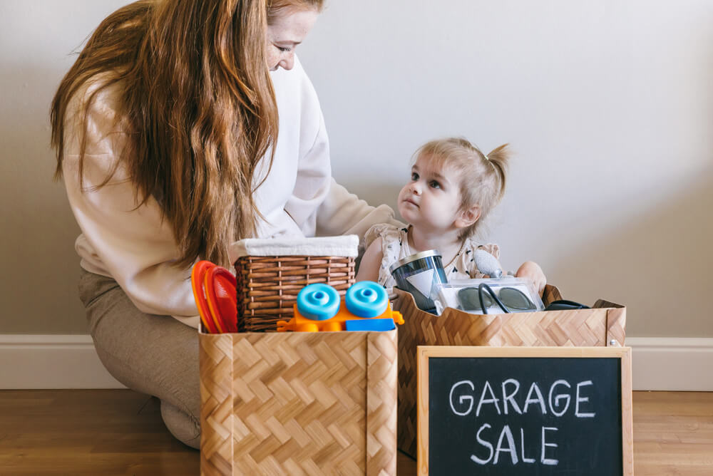a mother and her daughter gather told toys for a garage sale
