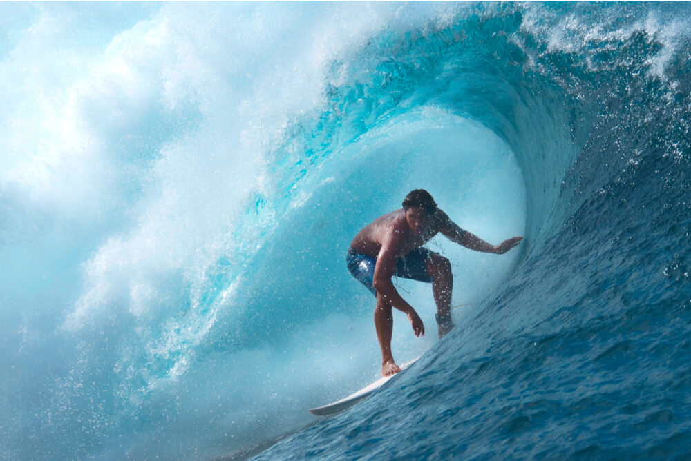 a guy with travel insurance for surfers surfing a tube wave