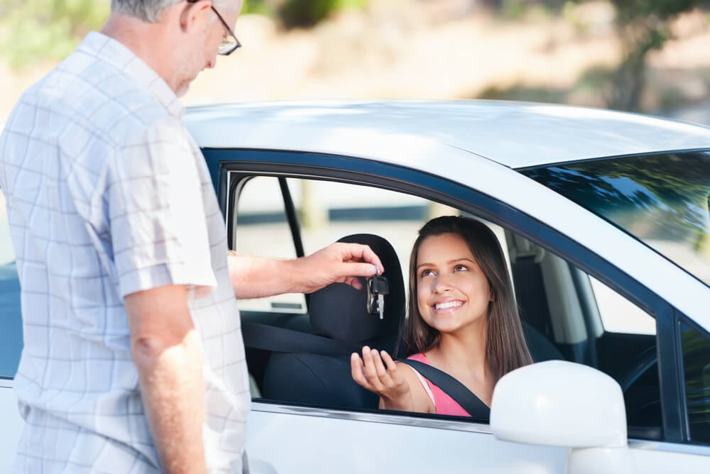 Young driver receiving keys to their first car