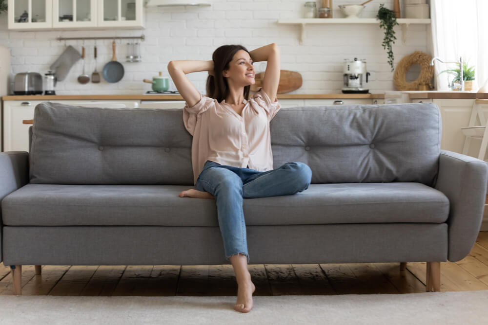 a woman sitting on the couch in her apartment