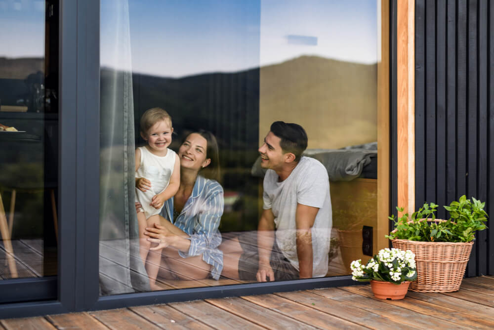 A family looking outside glass door of home