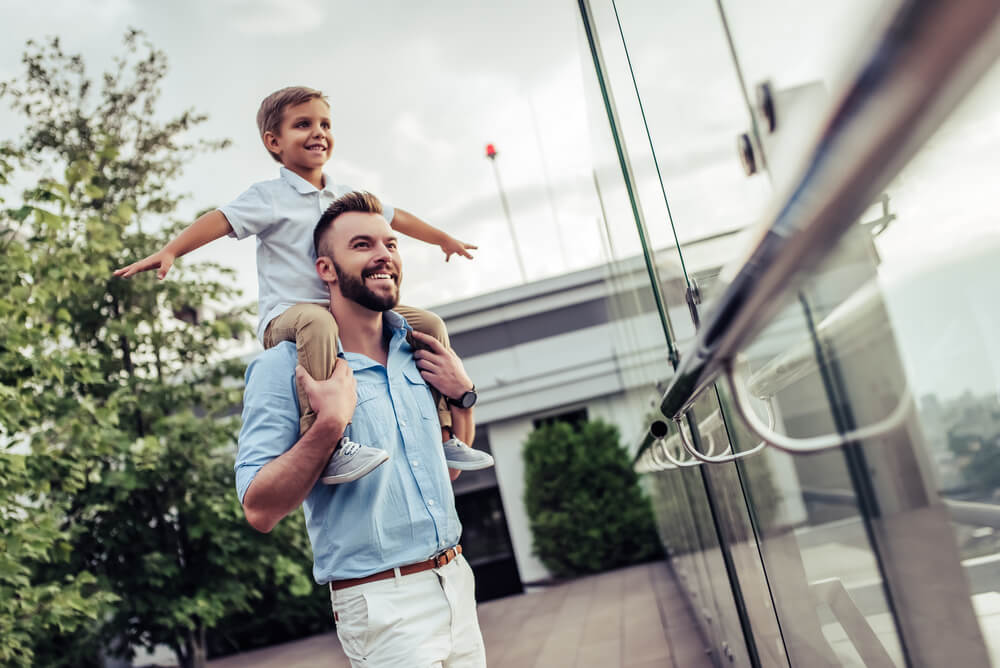 A father and son looking out from the deck of their house