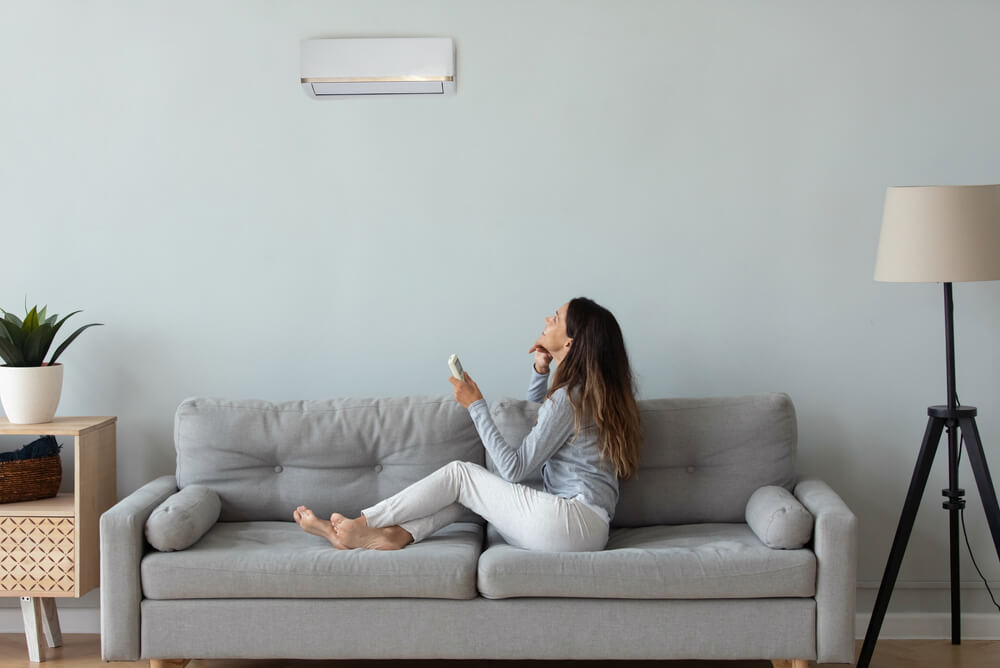 A woman relaxing on a couch under the air conditioning