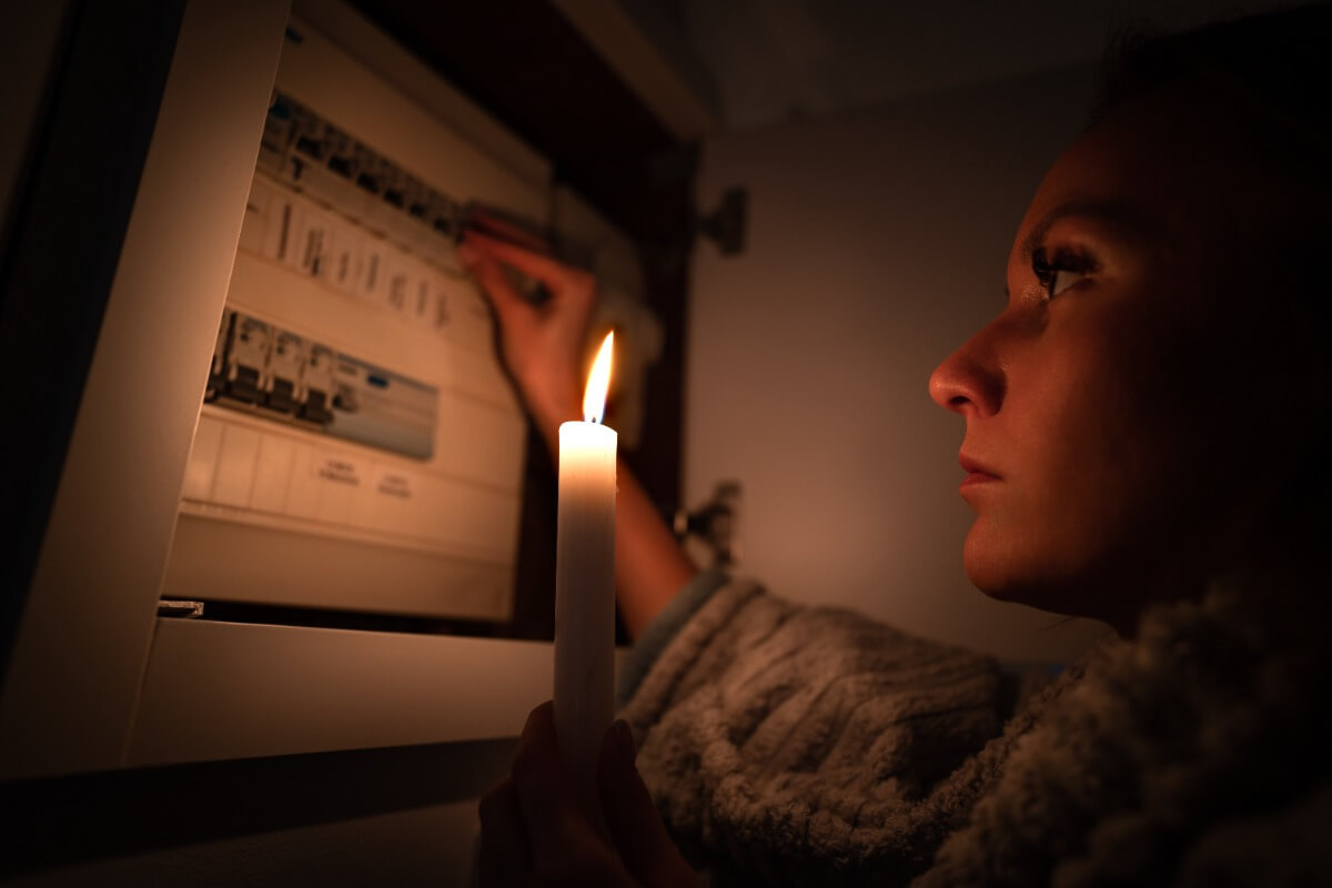 woman holding candle after energy was disconnected