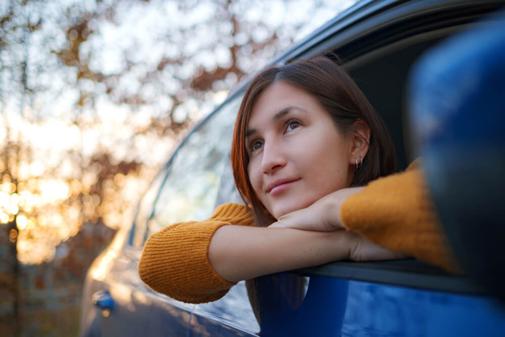 A woman leaning out of a car