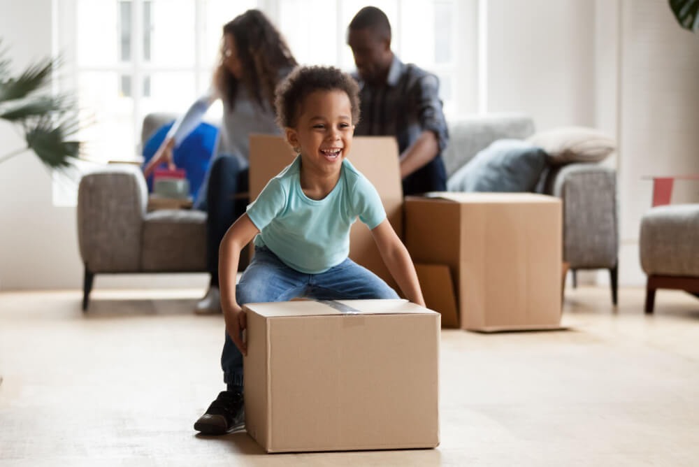 Married couple and child unpacking moving boxes