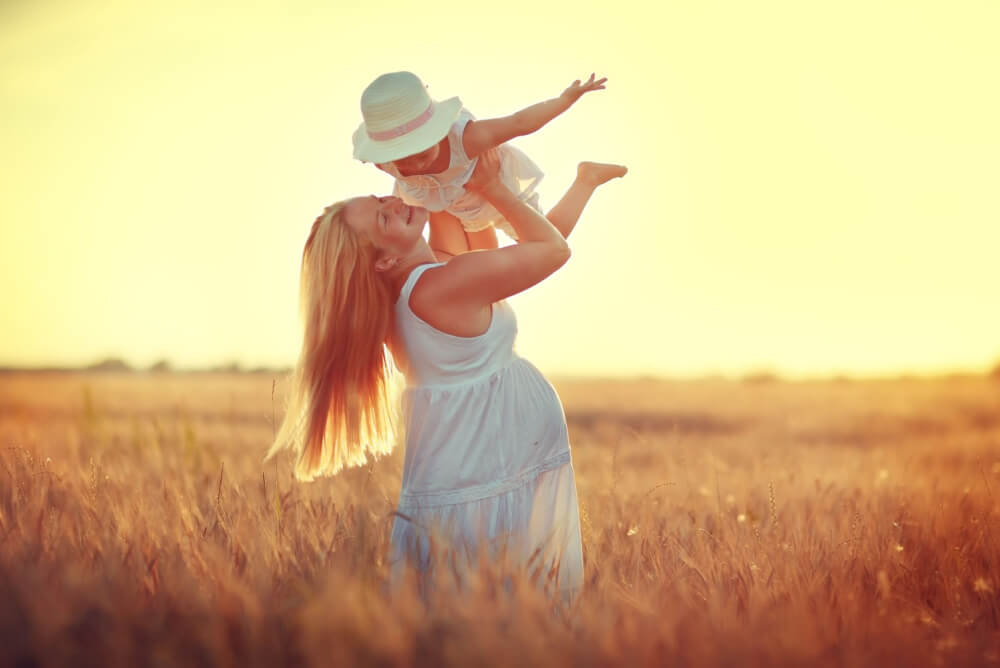 Pregnant mother and child in a field