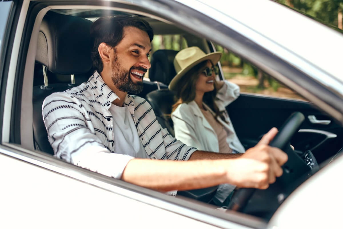 a man and woman driving a car through the Qld Outback