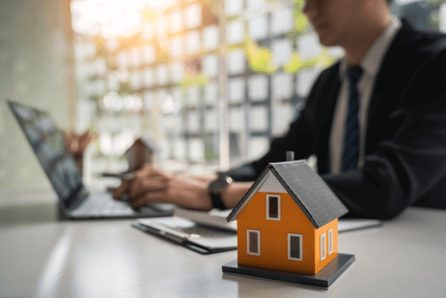 man at desk with mini home