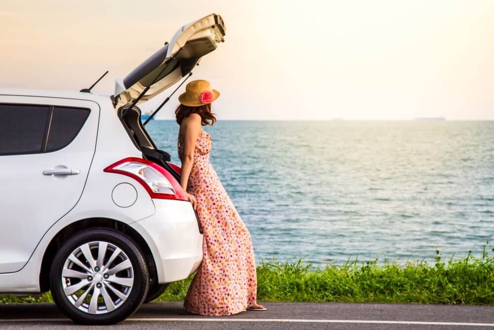 Lady drives car on coast road