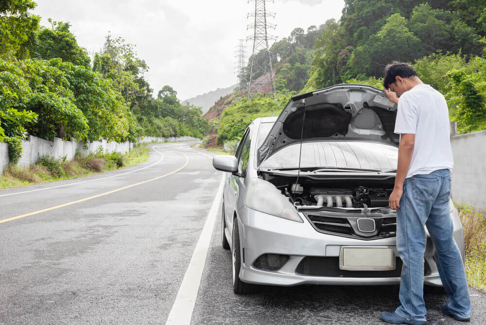 Man looking at overheated engine bay