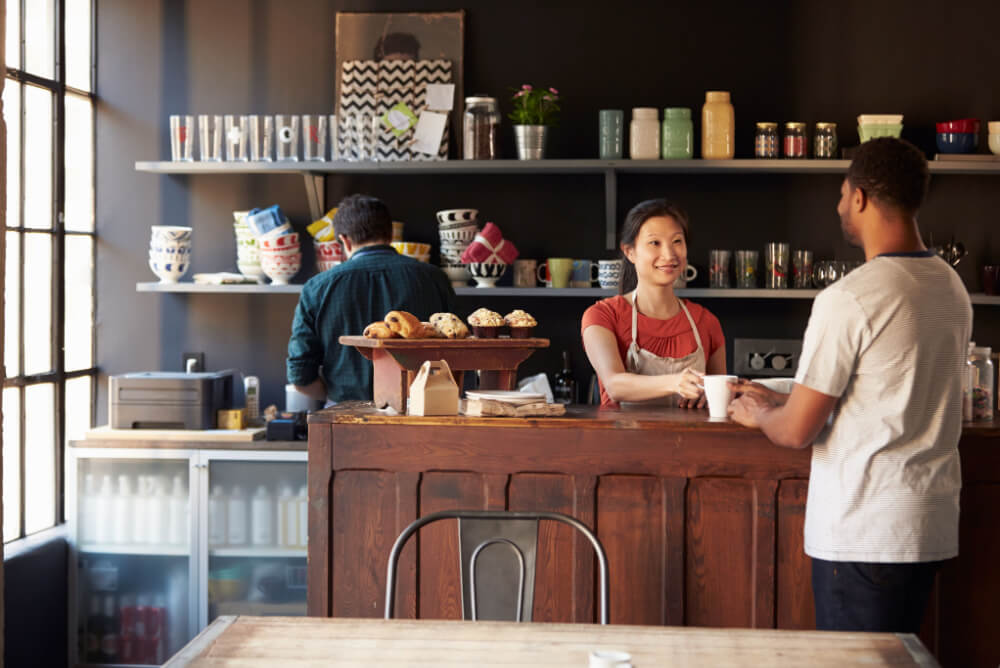 cafe owner with customer representing small business insurance
