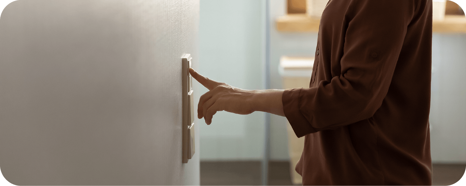 a person turning off the light at the wall