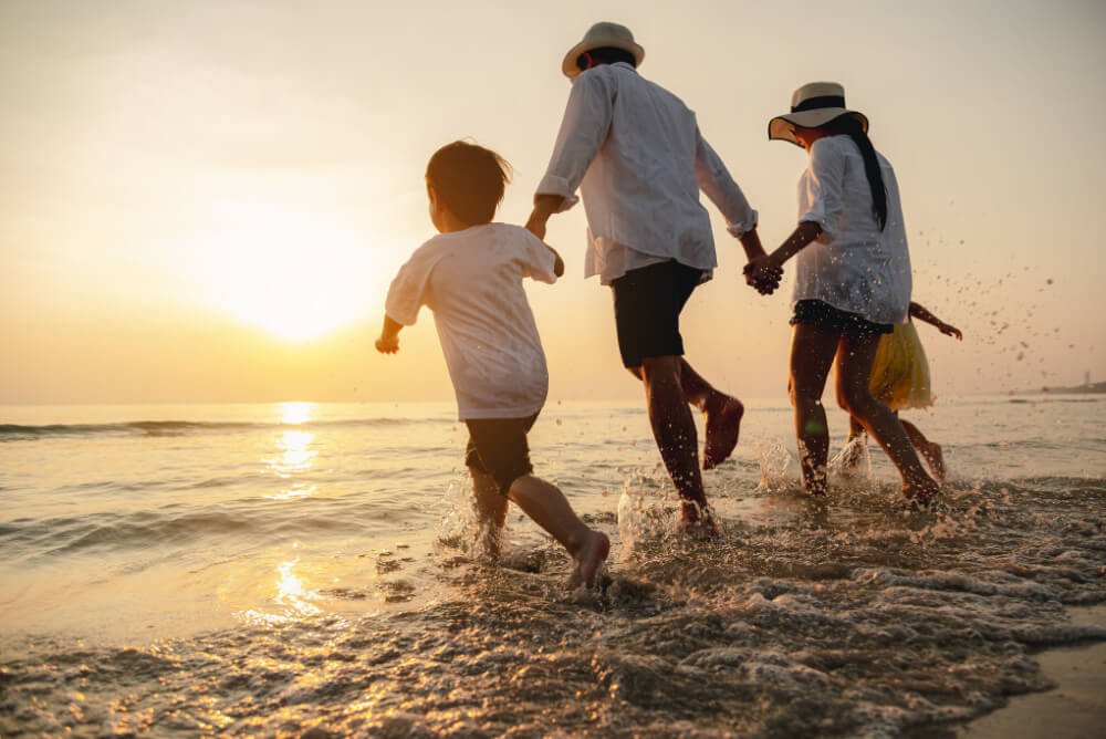 Family with accidental death insurance play on beach