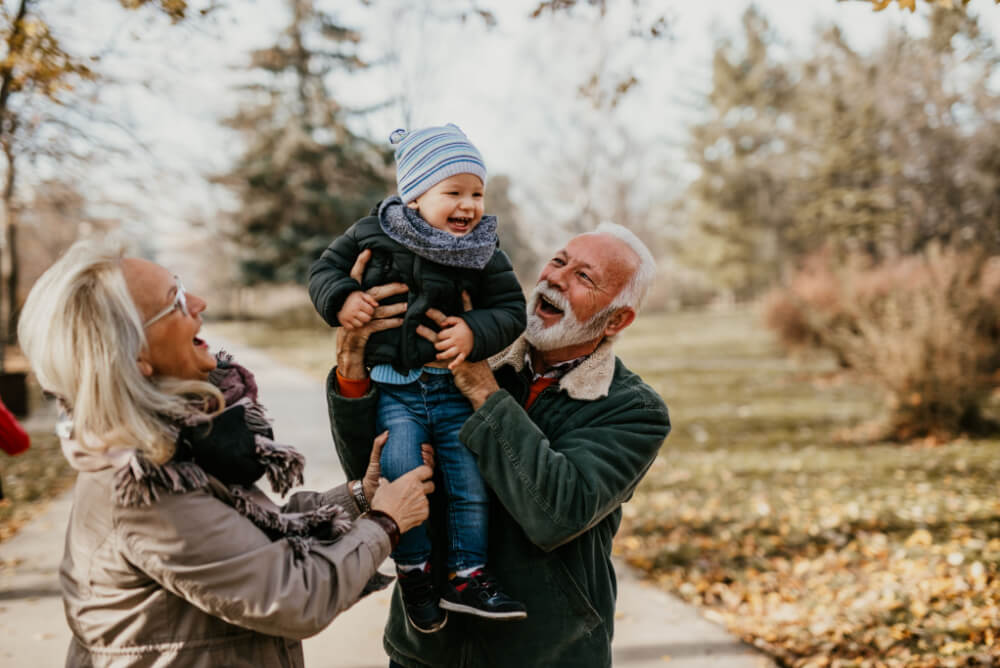 Grandparents with funeral insurance play with grandson