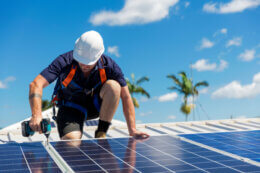 Man on roof installing solar panels
