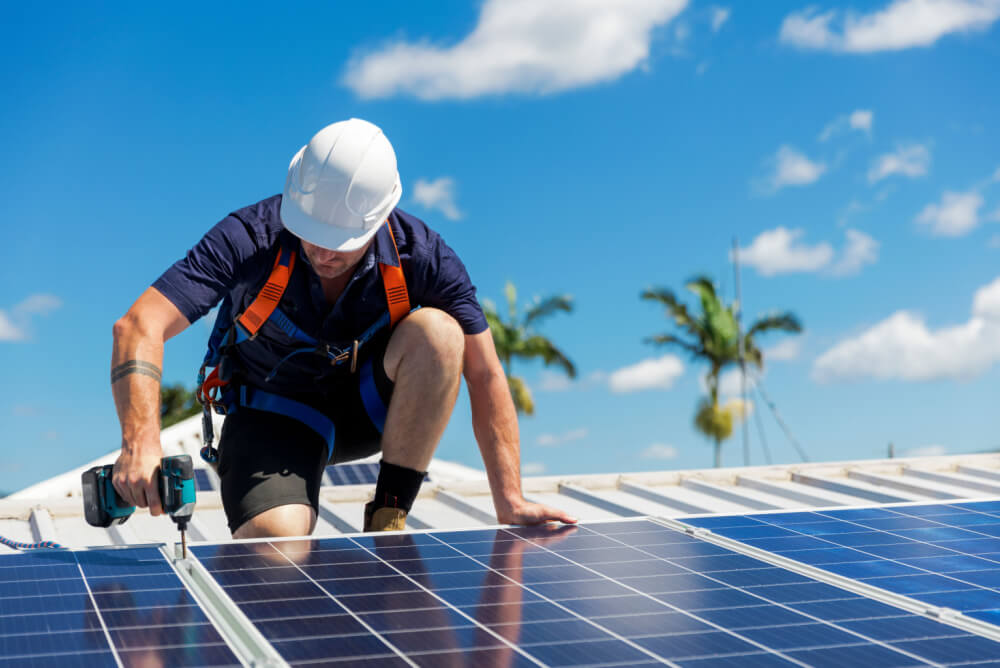 Man on roof installing solar panels