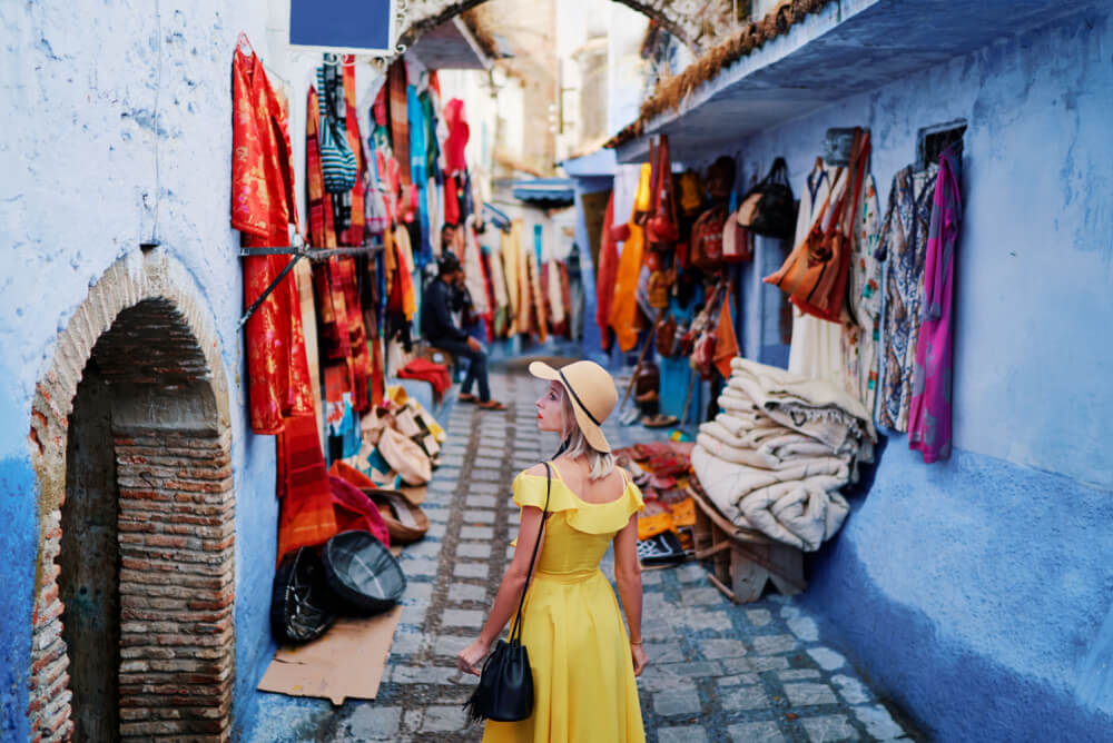 Woman walking down street in blue city Chefchaouen, Morocco