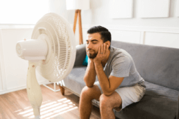 australian man cooling down with a fan