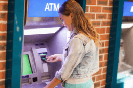 woman wasting money at atm