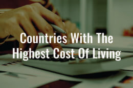 An image of a hand holding a pen using a calculator